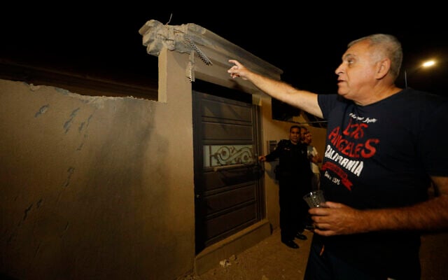 People stand by the wall of a home in the southern city of Sderot damaged by a rocket fired from the Gaza Strip, November 1, 2019. (AP Photo/Tsafrir Abayov) People stand by the wall of a home in the southern city of Sderot damaged by a rocket fired from the Gaza Strip, November 1, 2019. (AP Photo/Tsafrir Abayov)