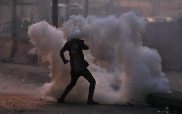 An anti-government protester is surrounded by tear gas fired by Iraqi security forces in an effort to disperse demonstrators, in central Baghdad, Iraq, November 10, 2019. (Hadi Mizban/AP) An anti-government protester is surrounded by tear gas fired by Iraqi security forces in an effort to disperse demonstrators, in central Baghdad, Iraq, November 10, 2019. (Hadi Mizban/AP)