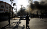 Illustrative: Police stand guard after a factory was hit by a rocket fired from the Gaza Strip, in Sderot, southern Israel November 12, 2019. (AP Photo/Tsafrir Abayov)