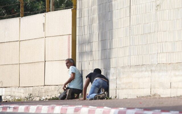 People take cover during an air-raid warning siren in Sderot, southern Israel on November 13, 2019. (AP/Ariel Schalit) People take cover during an air-raid warning siren in Sderot, southern Israel on November 13, 2019. (AP/Ariel Schalit)