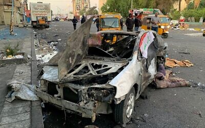 A damaged vehicle sits at the site of a bomb attack near Tahrir square in Baghdad, Iraq, Nov. 16, 2019 (AP Photo/Ali Abdul Hassan)