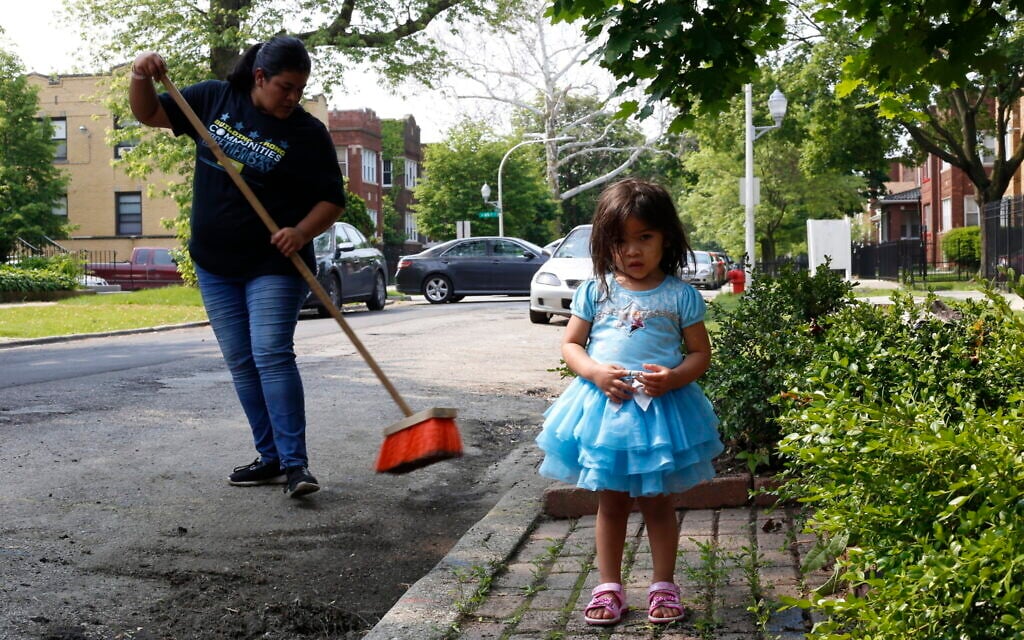 Jessica Garcia, left, sweeps the street in front of her new home as daughter Kayleen Garcia, age 2, stands in the foreground in Chicago on June 1, 2019. (AP Photo/Martha Irvine) Jessica Garcia, left, sweeps the street in front of her new home as daughter Kayleen Garcia, age 2, stands in the foreground in Chicago on June 1, 2019. (AP Photo/Martha Irvine)