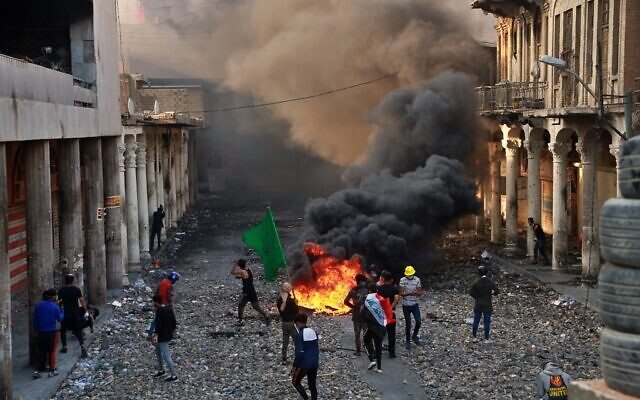 Anti-government protesters set fire while security forces close Rasheed Street during clashes in Baghdad, Iraq, Nov. 28, 2019 (AP Photo/Khalid Mohammed) Anti-government protesters set fire while security forces close Rasheed Street during clashes in Baghdad, Iraq, Nov. 28, 2019 (AP Photo/Khalid Mohammed)
