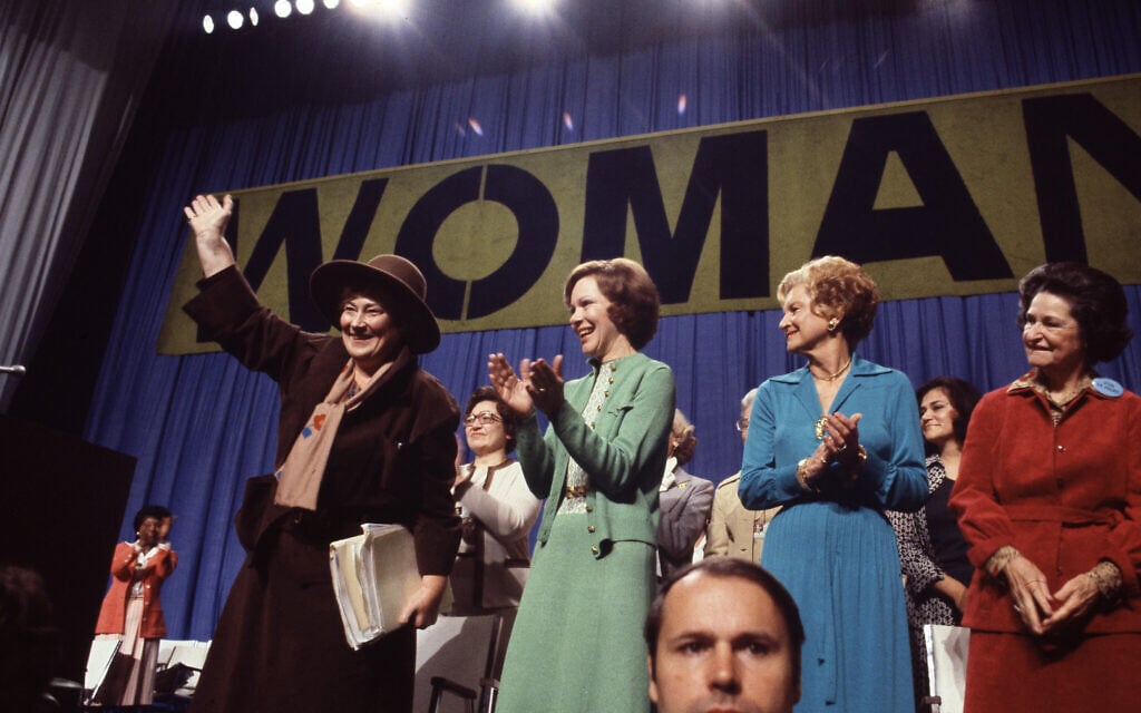 Former Congresswoman Bella Abzug, (D-NY) waves as first ladies Rosalynn Carter, Betty Ford and Lady Bird Johnson applaud at the National Women's Conference in Houston, Texas, November 19, 1977. (AP Photo/Greg Smith)