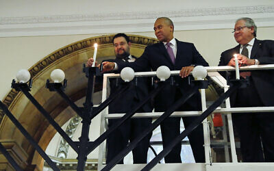 From left, Rabbi Rachmiel Liberman, then Massachusetts Governor Deval Patrick and Massachusetts House Speaker Robert DeLeo light candles on an 18-foot menorah to mark the arrival of Hanukkah during a ceremony at the Statehouse in Boston, December 16, 2014. (AP Photo/Elise Amendola)