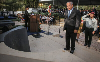 Prime Minister Benjamin Netanyahu stands in front of the tombstone of late prime minister Yitzhak Rabin during a memorial service marking 23 years since the assassination, held at Mount Herzl cemetery in Jerusalem on October 21, 2018. (Marc Israel Sellem/POOL)