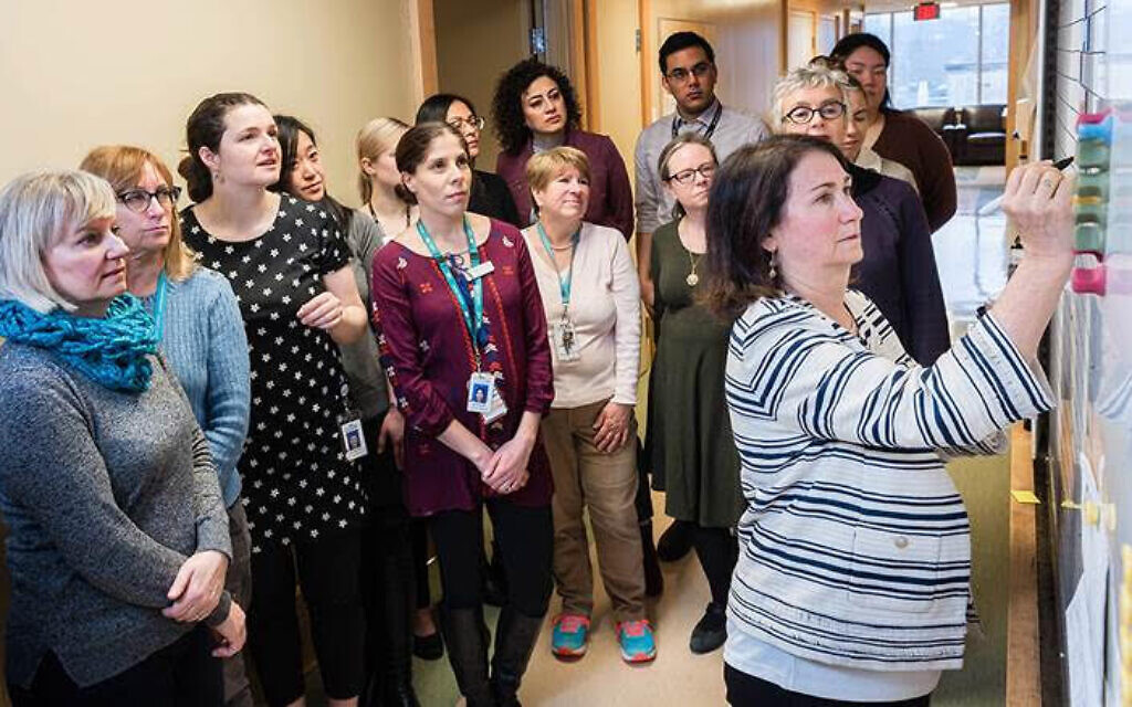 Dr. Neora Pick at the whiteboard in the Oak Tree Clinic during the morning staff huddle where collaborative interdisciplinary health care professionals discuss the patients they'll see that day and strategize on how best to treat them. (Courtesy)