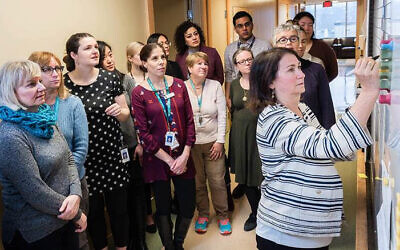 Dr. Neora Pick at the whiteboard in the Oak Tree Clinic during the morning staff huddle where collaborative interdisciplinary health care professionals discuss the patients they'll see that day and strategize on how best to treat them. (Courtesy)