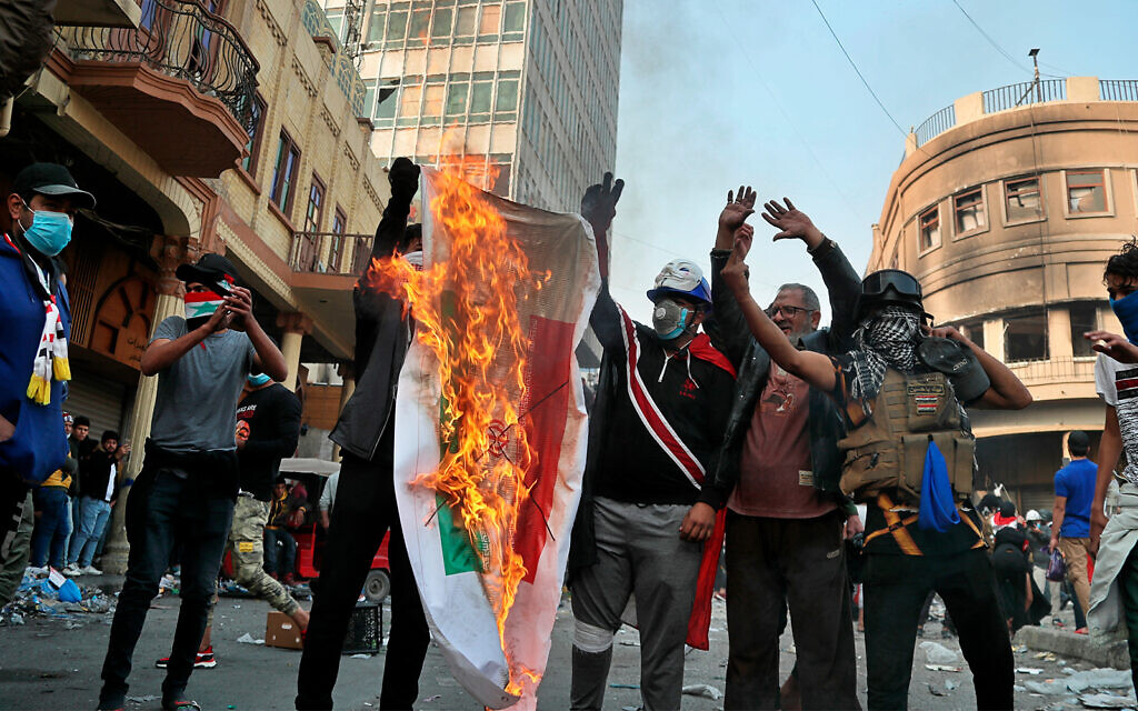 Iraqi anti-government protesters burn an Iranian flag during protests in Baghdad, Iraq, November 29, 2019. (AP Photo/Hadi Mizban) Iraqi anti-government protesters burn an Iranian flag during protests in Baghdad, Iraq, November 29, 2019. (AP Photo/Hadi Mizban)
