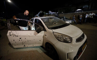 A man checks a car damaged by shrapnel from a missile fired from Gaza into Sderot, Israel, November 1, 2019. (AP Photo/Tsafrir Abayov)