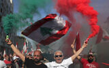 Anti-government protesters wave Lebanese national flags during a civil parade at the in downtown Beirut, Lebanon, November 22, 2019. (AP Photo/Hassan Ammar)