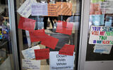Signs posted on windows and doors at Syracuse University display anti-racism expressions, November 21, 2019, in Syracuse, New York. (AP Photo/Carolyn Thompson)