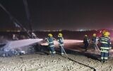 Firefighters work to extinguish a blaze on a helicopter that made an emergency landing in a field outside of Rahat in the Negev desert on November 26, 2019. (Fire and Rescue Services)