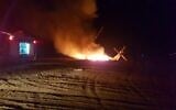 A firefighter works to extinguish a blaze on a helicopter that made an emergency landing in a field outside of Rahat in the Negev desert on November 26, 2019. (Fire and Rescue Services)
