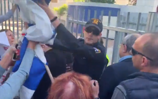 MK Ahmad Tibi (2nd right) is guarded by a policeman as he arrives at a speaking engagement in Ramat Hasharon, November 30, 2019 (Channel 12 video screenshot) MK Ahmad Tibi (2nd right) is guarded by a policeman as he arrives at a speaking engagement in Ramat Hasharon, November 30, 2019 (Channel 12 video screenshot)
