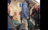 A Muslim woman (R) is seen trying to stop a man (C) from shouting anti-Semitic abuse at Jewish family with small children on the London Underground on November 22, 2109 (Screencapture/Twitter)