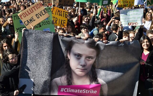People and students hold placards and a banner showing 16-year-old Swedish political activist Greta Thunberg, who seeks to stop global warming and climate change, as they take part in a protest against global warming in central Rome on March 15, 2019. (Andreas Solaro/AFP) People and students hold placards and a banner showing 16-year-old Swedish political activist Greta Thunberg, who seeks to stop global warming and climate change, as they take part in a protest against global warming in central Rome on March 15, 2019. (Andreas Solaro/AFP)