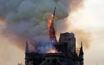 The steeple and spire of the landmark Notre-Dame Cathedral collapses as the cathedral is engulfed in flames in central Paris on April 15, 2019. (Photo by Geoffroy VAN DER HASSELT / AFP)