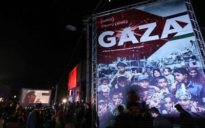 Palestinians watch a film during the opening ceremony of the Red Carpet Human Rights Film Festival, in front of the abandoned Cinema Amer building in Gaza City, December 4, 2019. (Photo by MAHMUD HAMS / AFP)