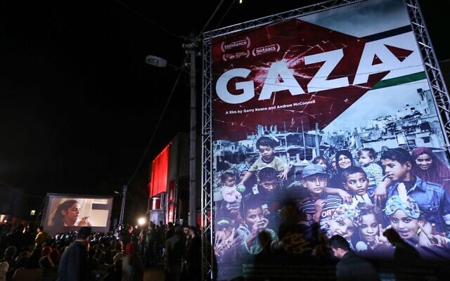 Palestinians watch a film during the opening ceremony of the Red Carpet Human Rights Film Festival, in front of the abandoned Cinema Amer building in Gaza City, December 4, 2019. (Photo by MAHMUD HAMS / AFP) Palestinians watch a film during the opening ceremony of the Red Carpet Human Rights Film Festival, in front of the abandoned Cinema Amer building in Gaza City, December 4, 2019. (Photo by MAHMUD HAMS / AFP)