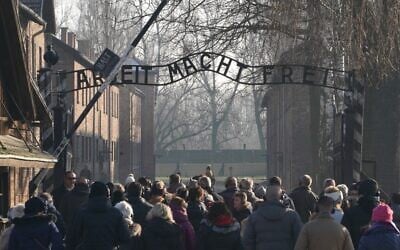 Visitors enter through the main gate with the inscription "Arbeit macht frei" (literally in English: "work makes (one) free") at the entrance to the Auschwitz German Nazi death camp ahead of German Chancellor Angela Merkel's landmark visit in Oswiecim, Poland, on December 5, 2019. (JANEK SKARZYNSKI / AFP)