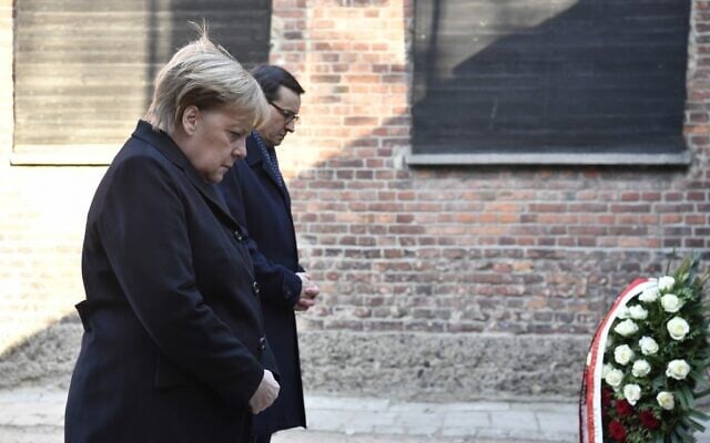 German Chancellor Angela Merkel and Polish Prime Minister Mateusz Morawiecki lay wreathes at the Death Wall during their visit at the former German Nazi death camp Auschwitz-Birkenau in Oswiecim, Poland on December 6, 2019. (John Macdougall/AFP)