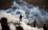 Illustrative: Palestinians clash with Israeli troops during along the border with Israel, east of Bureij in the central Gaza Strip, on December 6, 2019. (Mahmud Hams/AFP)