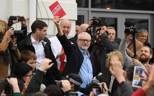 Britain's opposition Labour party leader Jeremy Corbyn holds his party's manifesto book aloft as he addresses a crowd outside the venue of a general election campaign event in Swansea, south Wales on December 7, 2019. (Daniel Leal-Olivas/AFP) Britain's opposition Labour party leader Jeremy Corbyn holds his party's manifesto book aloft as he addresses a crowd outside the venue of a general election campaign event in Swansea, south Wales on December 7, 2019. (Daniel Leal-Olivas/AFP)