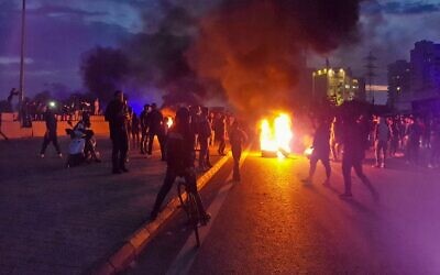 Illustrative: Lebanese anti-government protesters burn tires to block a road in al-Mina town in the northern port city of Tripoli on December 10, 2019, following the collapse of a house overnight in the area that killed two siblings. (Fathi AL-MASRI / AFP)