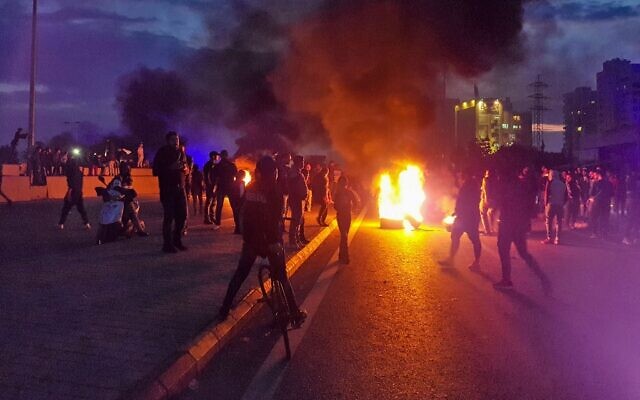 Illustrative: Lebanese anti-government protesters burn tires to block a road in al-Mina town in the northern port city of Tripoli on December 10, 2019, following the collapse of a house overnight in the area that killed two siblings. (Fathi AL-MASRI / AFP) Illustrative: Lebanese anti-government protesters burn tires to block a road in al-Mina town in the northern port city of Tripoli on December 10, 2019, following the collapse of a house overnight in the area that killed two siblings. (Fathi AL-MASRI / AFP)