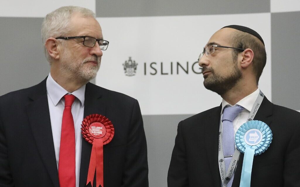 Britain's opposition Labour Party leader Jeremy Corbyn (L) exchanges a glance with the Brexit Party candidate Yosef David (R) as they stand on the stage waiting for the result from the election race for the constituency of Islington North at the count centre in Islington, north London, on December 13, 2019 (Isabel Infantes/AFP) Britain's opposition Labour Party leader Jeremy Corbyn (L) exchanges a glance with the Brexit Party candidate Yosef David (R) as they stand on the stage waiting for the result from the election race for the constituency of Islington North at the count centre in Islington, north London, on December 13, 2019 (Isabel Infantes/AFP)