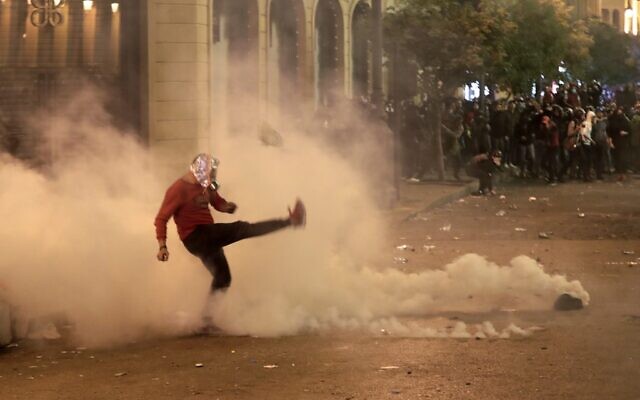 A Lebanese demonstrator kicks back a tear-gas canister during clashes with riot police in the capital Beirut on December 15, 2019. (ANWAR AMRO / AFP) A Lebanese demonstrator kicks back a tear-gas canister during clashes with riot police in the capital Beirut on December 15, 2019. (ANWAR AMRO / AFP)