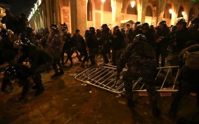 Lebanese security forces remove metal barriers as they clash with protesters during an anti-government demonstration in the downtown area of the capital Beirut on December 15, 2019. (Photo by ANWAR AMRO / AFP) Lebanese security forces remove metal barriers as they clash with protesters during an anti-government demonstration in the downtown area of the capital Beirut on December 15, 2019. (Photo by ANWAR AMRO / AFP)