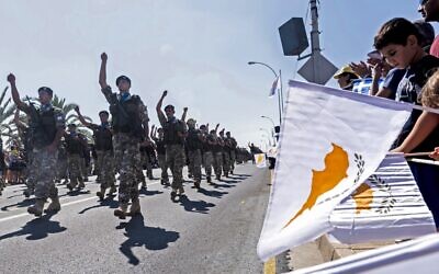In this photo from October 1, 2019, Cypriots wave the flags of Cyprus and Greece during a military parade marking the 59th anniversary of Cyprus' independence from British colonial rule, in the capital Nicosia. (Iakovos Hatzistavrou/AFP)
