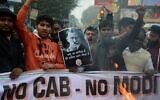 Protesters hold a poster comparing Indian Prime Minister Narendra Modi to Nazi German leader Adolf Hitler at a demonstration against India's new citizenship law in Siliguri on December 18, 2019. (Diptendu Dutta/AFP)