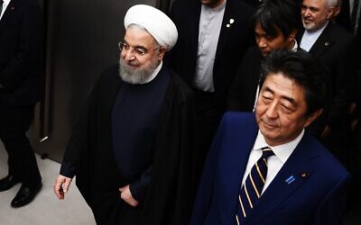 Iranian President Hassan Rouhani (L) walks with Japanese Prime Minister Shinzo Abe (R) to a meeting room at the prime minister's office in Tokyo on December 20, 2019. (Charly  Triballeau/Pool/AFP)
