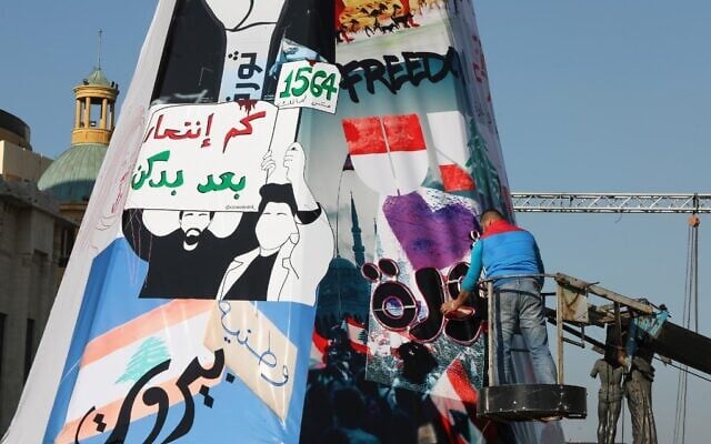 Lebanese anti-government protesters erect a Christmas tree made of protest banners in Beirut's Martyr Square on December 21, 2019. (ANWAR AMRO / AFP) Lebanese anti-government protesters erect a Christmas tree made of protest banners in Beirut's Martyr Square on December 21, 2019. (ANWAR AMRO / AFP)