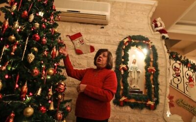 Hanadi Missak, a 48-year-old Christian woman, adjusts the ornaments on her Christmas tree, during an interview in her house in Gaza City, on December 22, 2019. (MAHMUD HAMS/AFP)