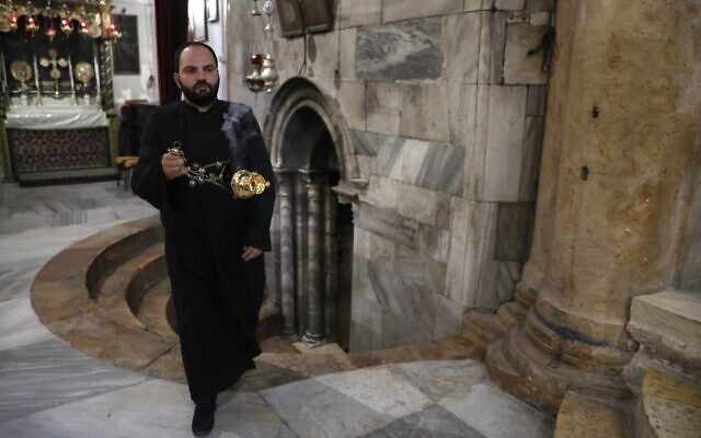 A Christian Armenian priest blesses the Church of the Nativity in the biblical West Bank city of Bethlehem on December 23, 2019. (AHMAD GHARABLI/AFP) A Christian Armenian priest blesses the Church of the Nativity in the biblical West Bank city of Bethlehem on December 23, 2019. (AHMAD GHARABLI/AFP)