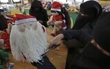 A Palestinian artisan puts the final touches on a Christmas toy at Zeina Association and Cooperative for Handicraft in Beit Hanoun in the northern Gaza Strip on December 24, 2019. (MOHAMMED ABED / AFP)