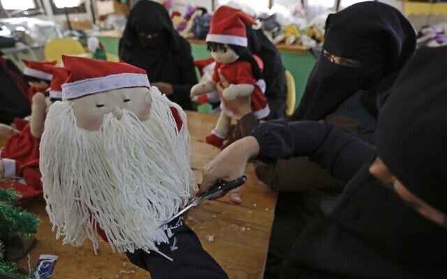 A Palestinian artisan puts the final touches on a Christmas toy at Zeina Association and Cooperative for Handicraft in Beit Hanoun in the northern Gaza Strip on December 24, 2019. (MOHAMMED ABED / AFP) A Palestinian artisan puts the final touches on a Christmas toy at Zeina Association and Cooperative for Handicraft in Beit Hanoun in the northern Gaza Strip on December 24, 2019. (MOHAMMED ABED / AFP)