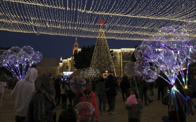 Tourists and pilgrims visit Manger Square outside the Church of the Nativity in the West Bank city of Bethlehem on December 24, 2019. (HAZEM BADER / AFP) Tourists and pilgrims visit Manger Square outside the Church of the Nativity in the West Bank city of Bethlehem on December 24, 2019. (HAZEM BADER / AFP)