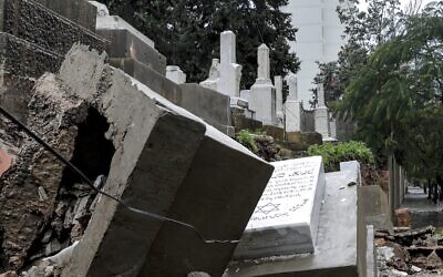 This picture taken on December 26, 2019, shows graves damaged during bad weather in a winter storm at the Jewish cemetery in the Lebanese capital Beirut. (Anwar Amro/AFP)