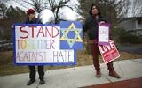 People hold signs of support near the house of Rabbi Chaim Rottenberg on December 29, 2019 in Monsey, New York. (Photo by Kena Betancur / AFP)