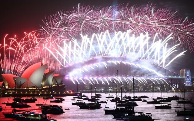 New Year's fireworks erupt over Sydney's iconic Harbour Bridge and Opera House (L) during the fireworks show on January 1, 2020. (Peter Parks/AFP)