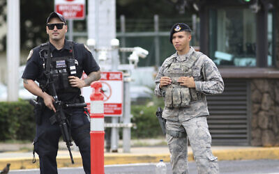 Security stands guard outside the main gate at Joint Base Pearl Harbor-Hickam, in Hawaii, Wednesday, Dec. 4, 2019. (AP Photo/Caleb Jones)