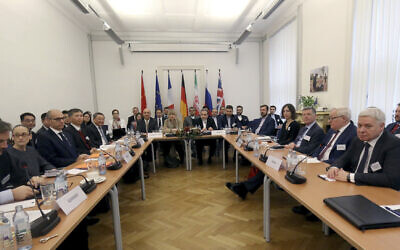 Officials at a bilateral meeting as part of the closed-door nuclear talks with Iran in Vienna, Austria, Friday, Dec. 6, 2019. (AP Photo/Ronald Zak)