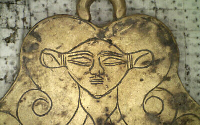 In this undated photo provided by the Greek Culture Ministry on, December 17, 2019, a golden pendant of the Egyptian goddess Hathor is seen that was found in a 3,500-year-old tomb discovered near the southwestern Greek town of Pylos. (Greek Culture Ministry via AP)