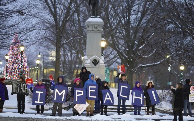 Protesters hold up signs to traffic on Park Square in Pittsfield, Massachusetts, supporting impeachment articles against US President Donald Trump, December 17, 2019. (Ben Garver/The Berkshire Eagle via AP) Protesters hold up signs to traffic on Park Square in Pittsfield, Massachusetts, supporting impeachment articles against US President Donald Trump, December 17, 2019. (Ben Garver/The Berkshire Eagle via AP)
