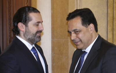 Lebanese Prime Minister-designate Hassan Diab, right, shakes hands with outgoing Prime Minister Saad Hariri, left, in Beirut, Lebanon, December 20, 2019 (Dalati Nohra via AP)